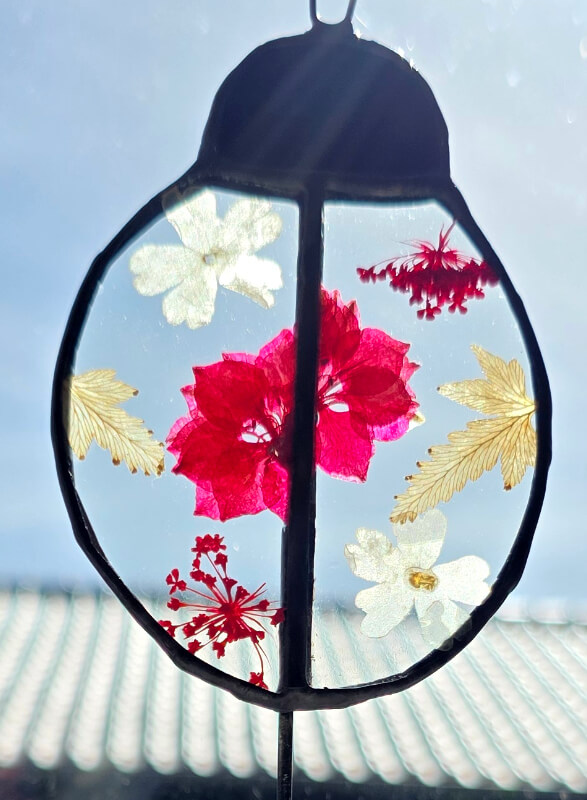 Studio dijkwater tiffany lieveheersbeestje droogbloemen zon 800px 72dpi Handgemaakte glaskunst lieveheersbeestje in Tiffany-techniek met droogbloemen tussen helder glas, zwart gepatineerd op houten voet, Studio Dijkwater Zeeland